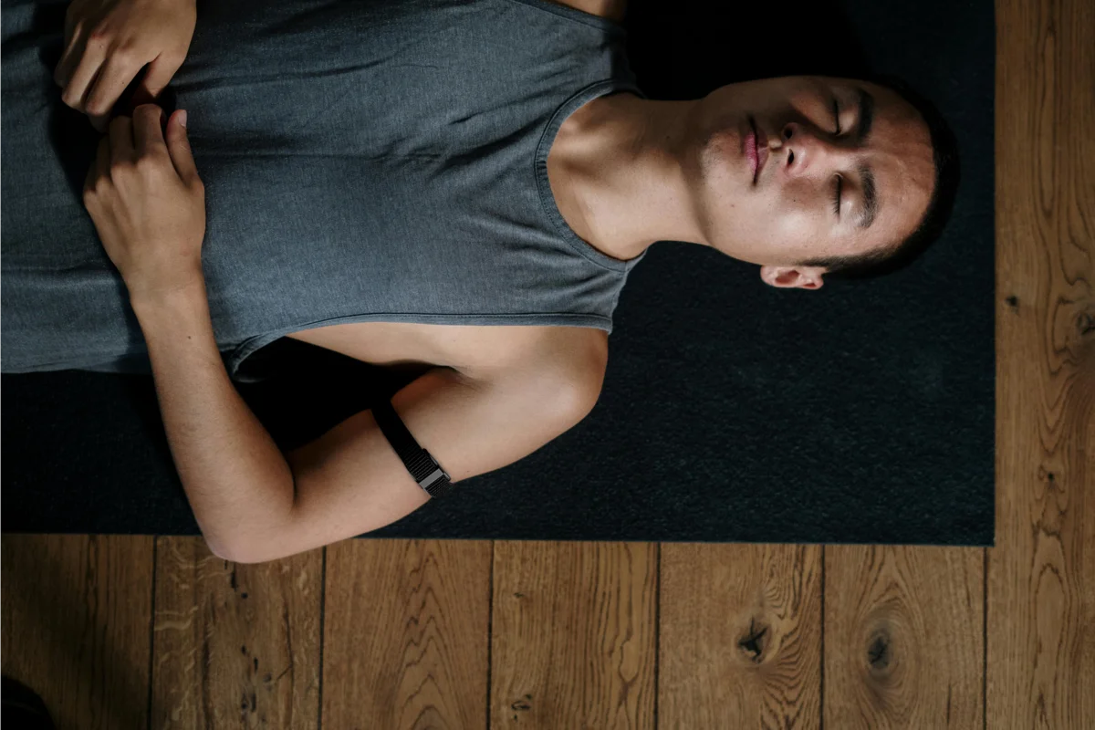 Man practicing yoga with health monitoring